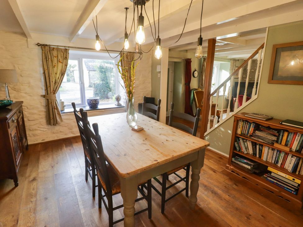 A dining room with a wooden table and chairs at Ty'r Wennol in Fishguard