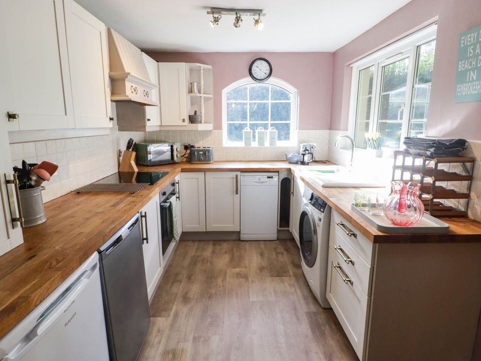 A kitchen with appliances and cabinets at Ty'r Wennol in Fishguard