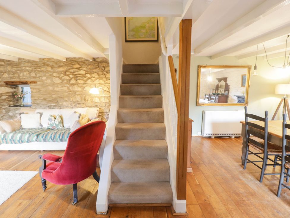 A living room with a staircase and seating area at Ty'r Wennol in Fishguard