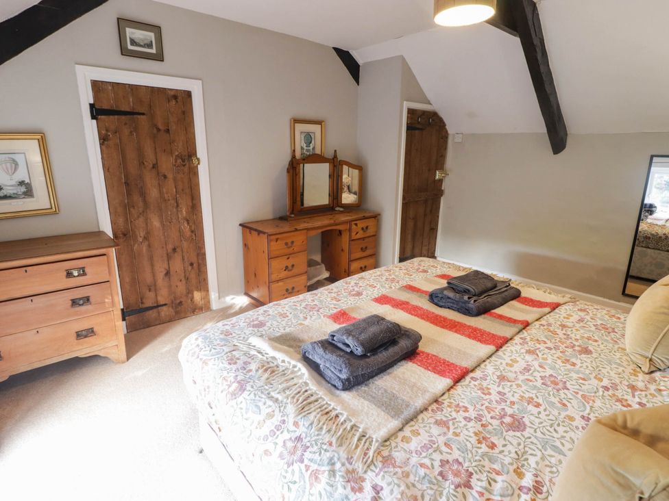 A bedroom with a bed and dressing table at Ty'r Wennol in Fishguard