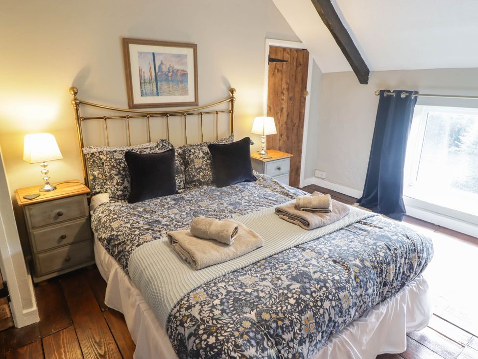 A bedroom with a bed and nightstand at Ty'r Wennol in Fishguard