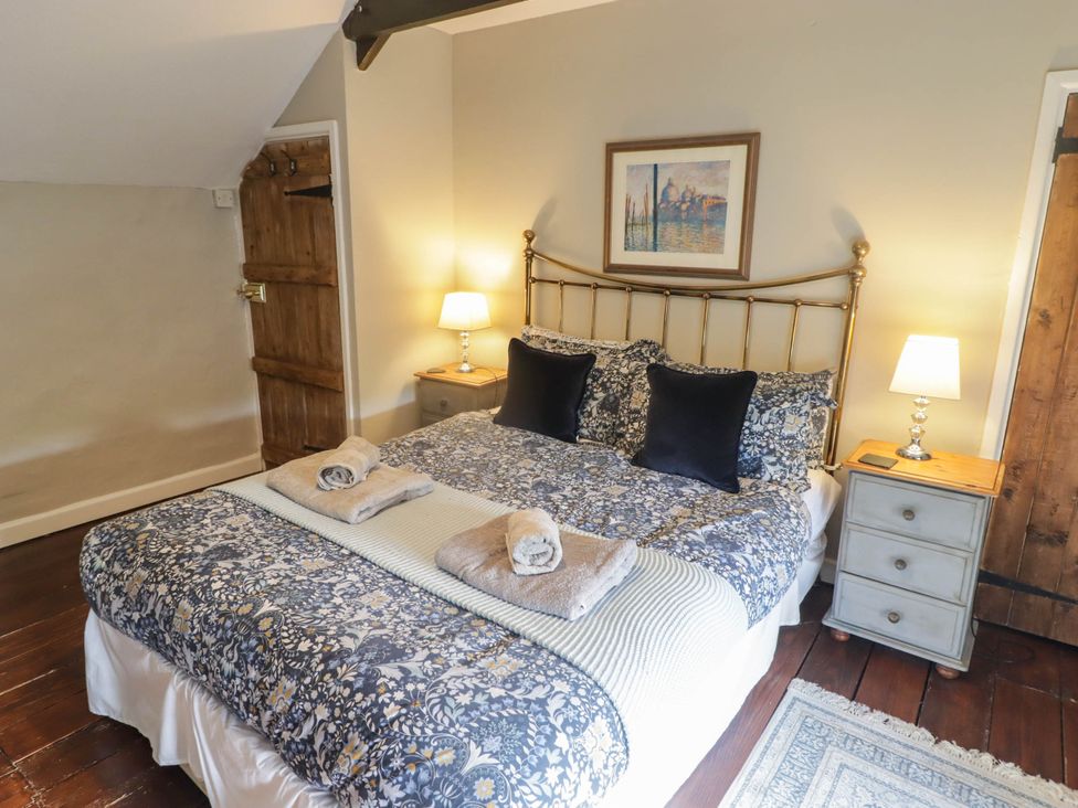 A bedroom with a bed and nightstand at Ty'r Wennol in Fishguard
