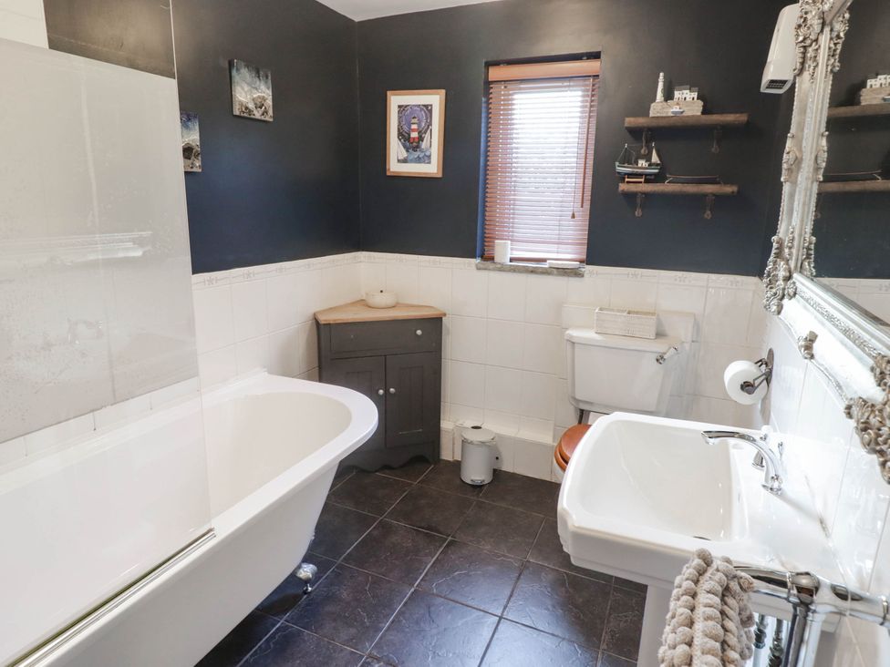 A bathroom with a bathtub and sink at Ty'r Wennol in Fishguard