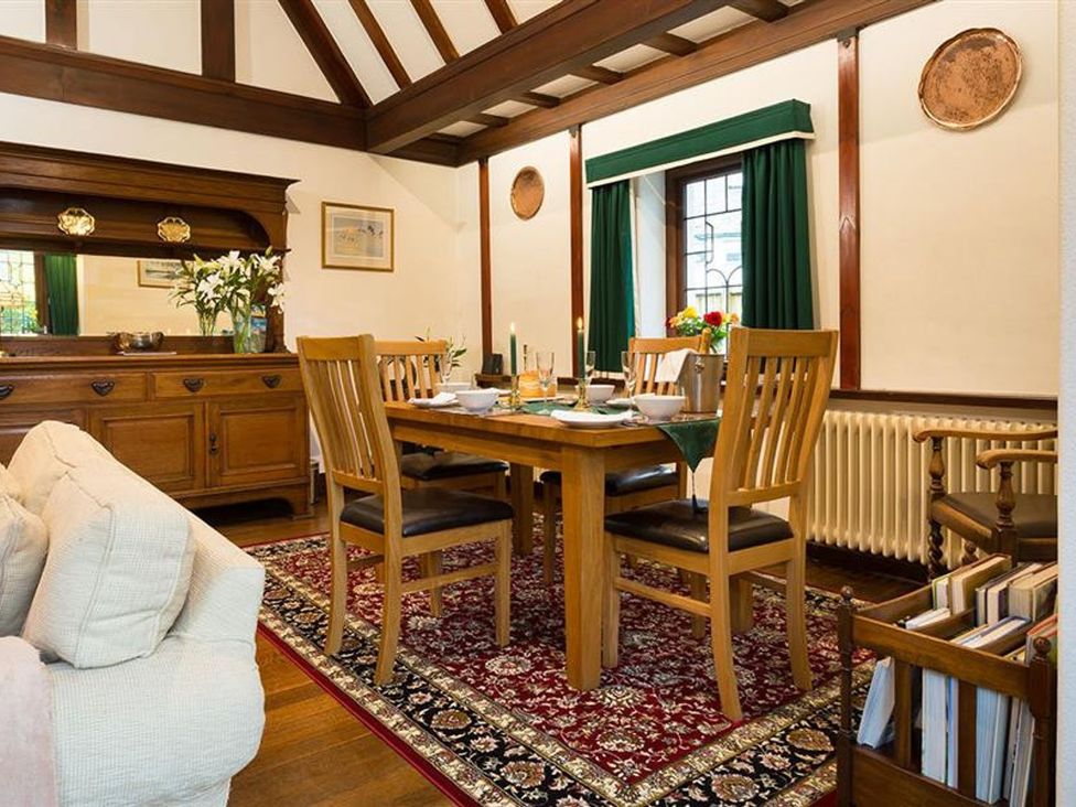 A dining room with a wooden table and chairs at White Gables in Ambleside