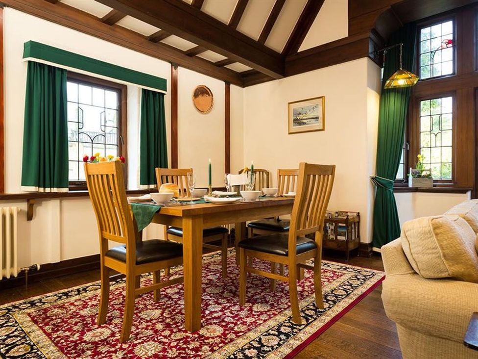 A dining room with a table set for a meal at White Gables in Ambleside
