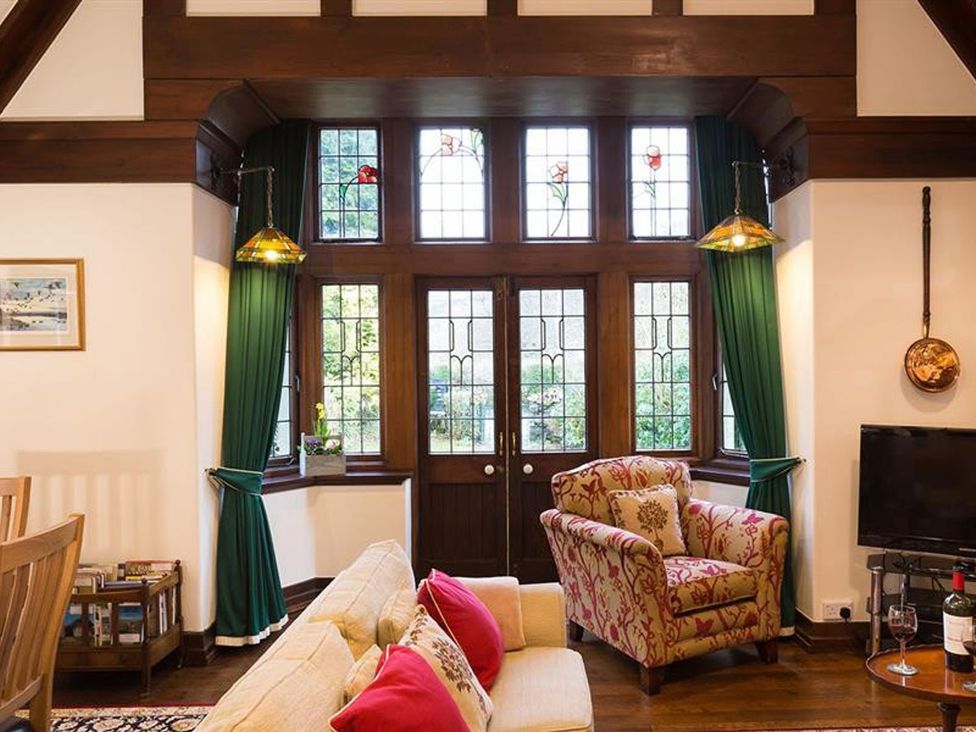 A living room with a sofa, chair, and television at White Gables in Ambleside