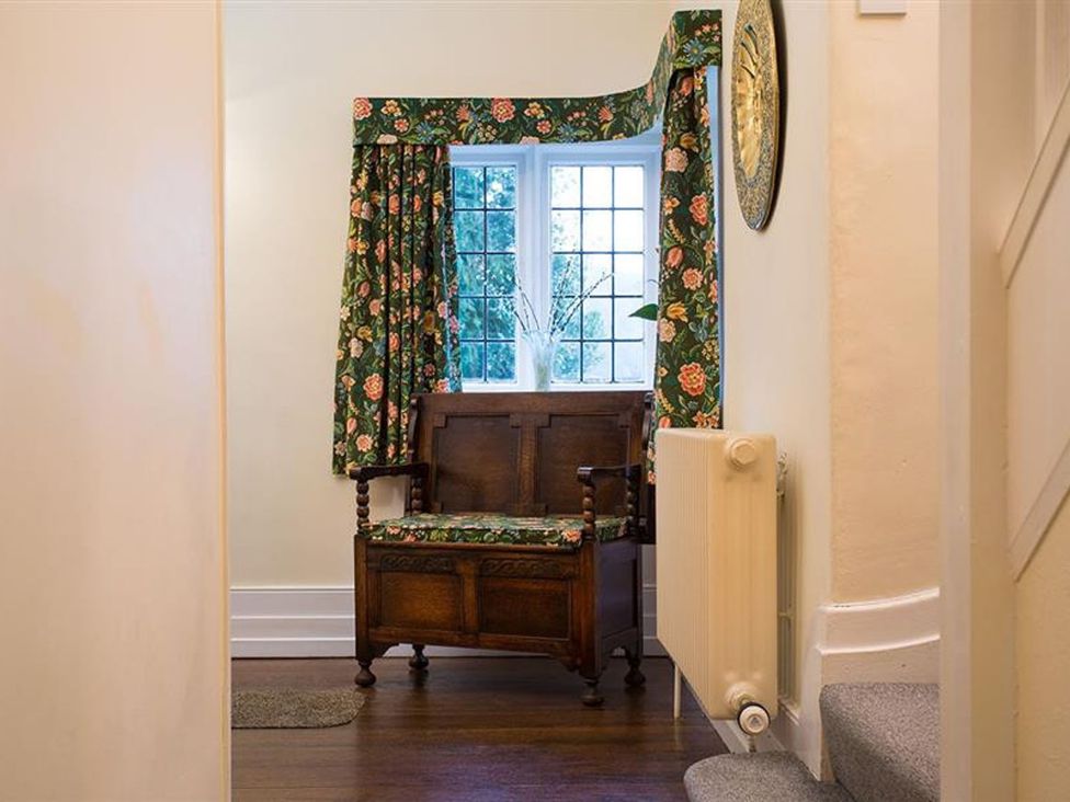 A hallway with a bench and curtains at White Gables in Ambleside