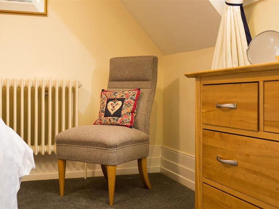 A chair with a pillow next to a radiator in the bedroom at White Gables in Ambleside