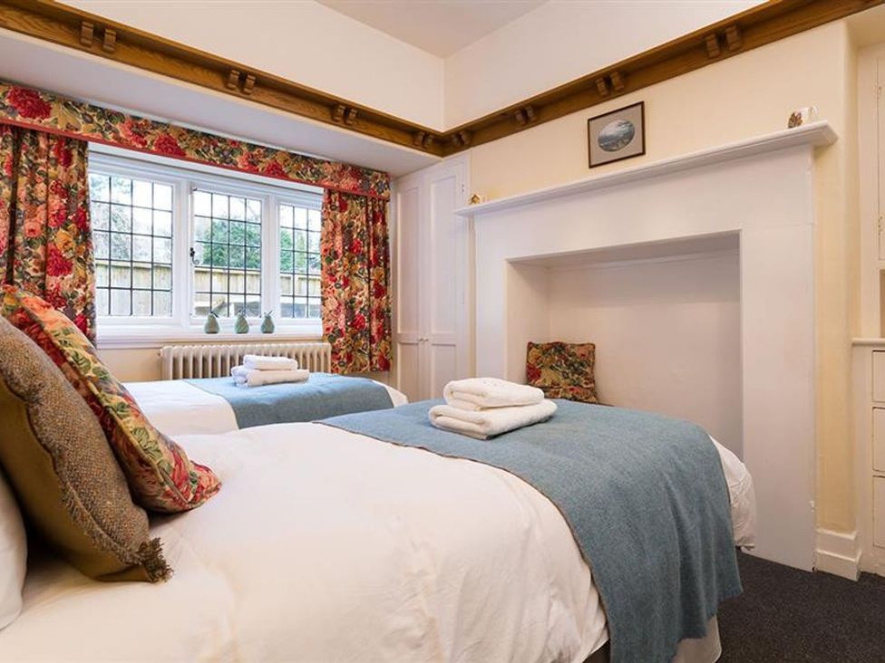 A bedroom with two beds and a window at White Gables in Ambleside
