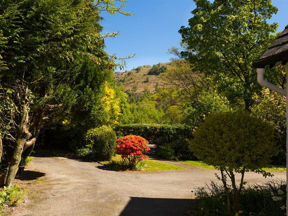 A garden with a gravel drive and flowers at White Gables in Ambleside
