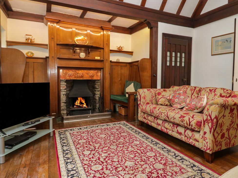 A living room with a fireplace and a sofa at White Gables in Grasmere
