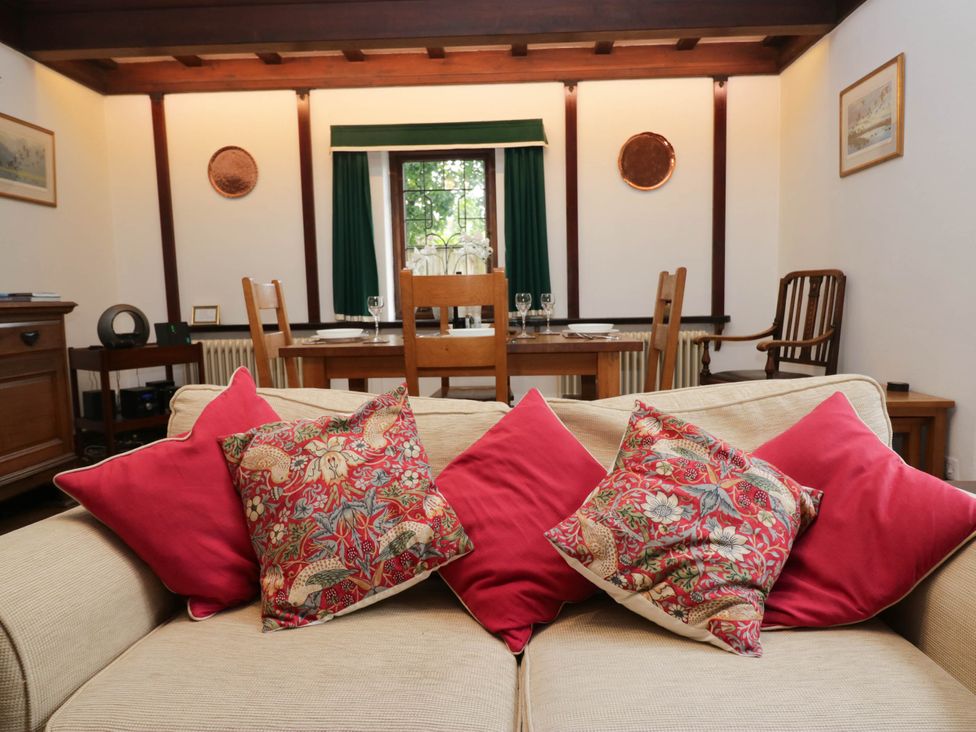 A living room with a sofa and dining table at White Gables in Grasmere