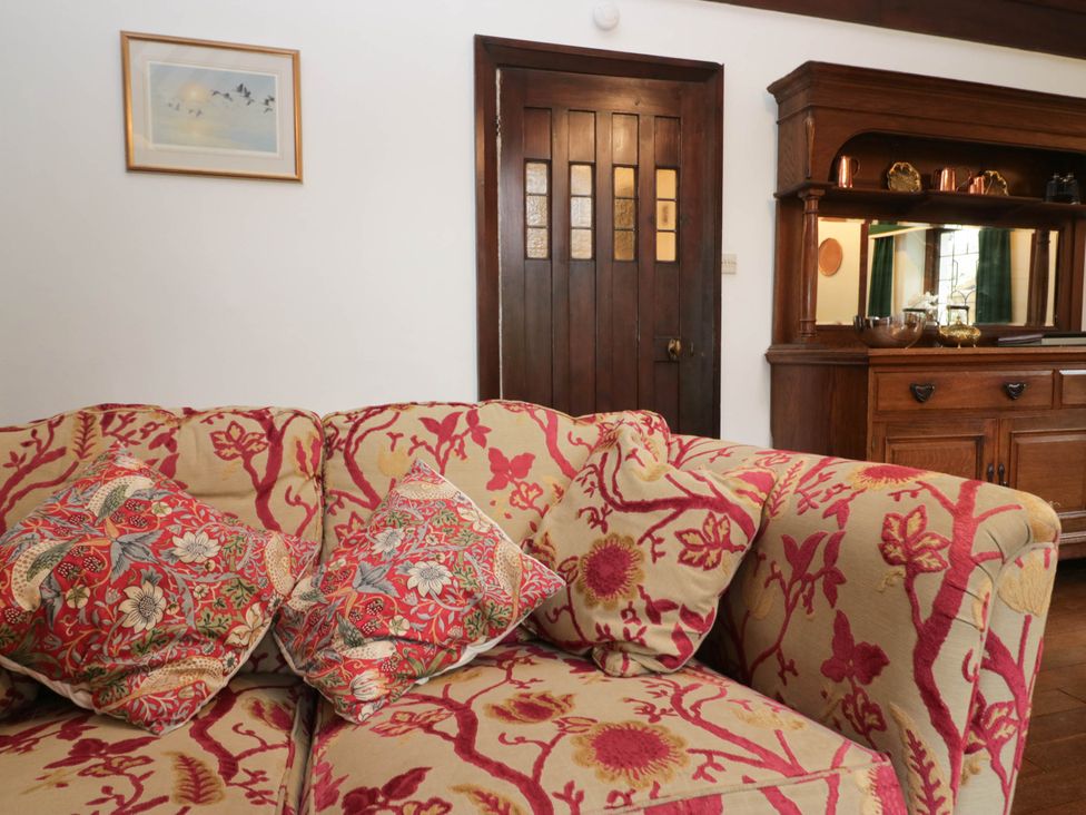 A living room with a sofa and wooden cabinet at White Gables in Grasmere