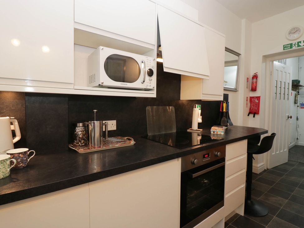 A kitchen with a microwave and cooker at White Gables in Grasmere