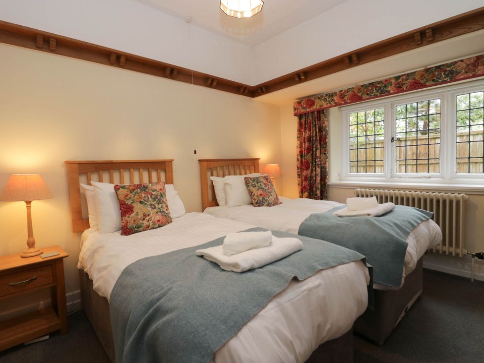 A bedroom with two beds and a window at White Gables in Grasmere