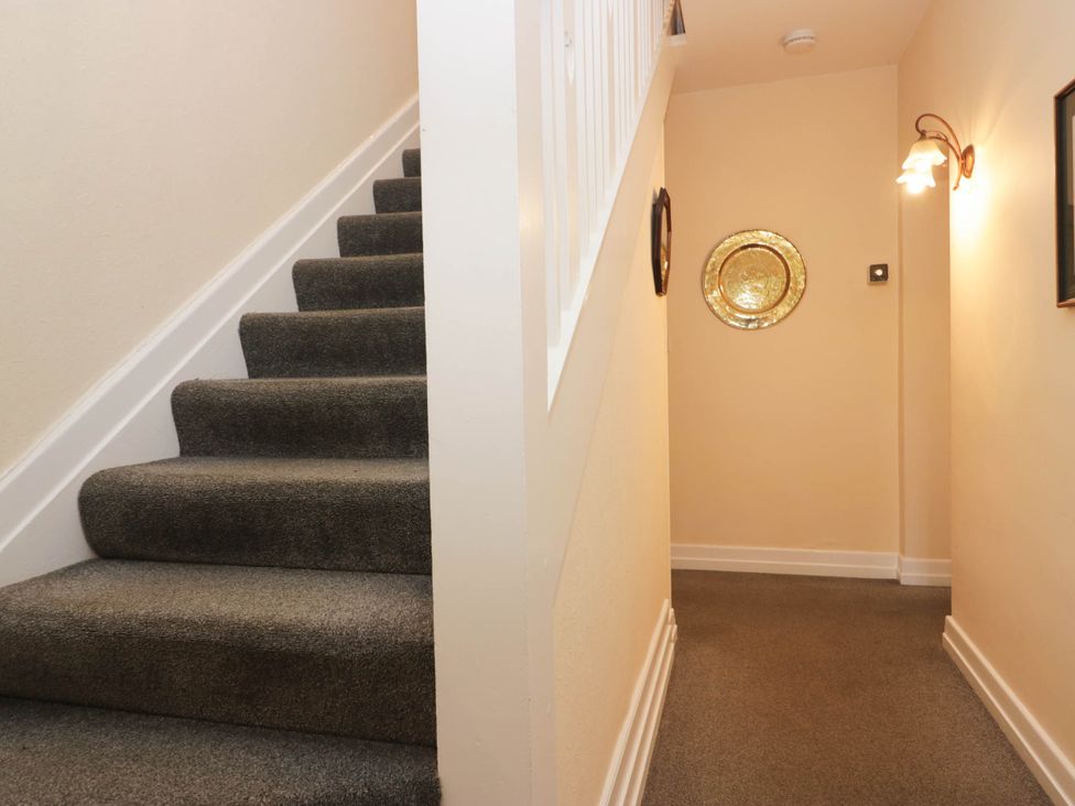 A staircase with a light fixture in a hallway at White Gables in Grasmere