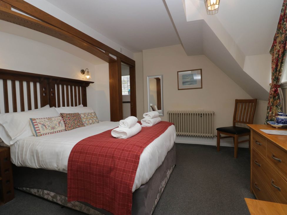 A bedroom with a bed and a chair at White Gables in Grasmere