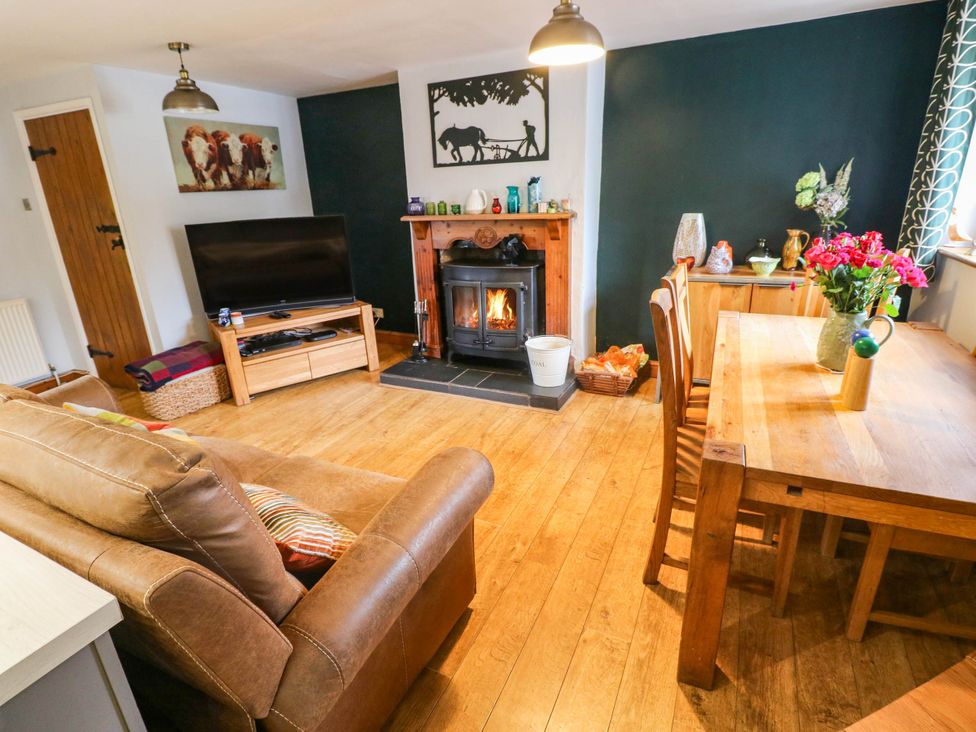 A living room with a fireplace and dining table at Greig House Farm in Abergavenny