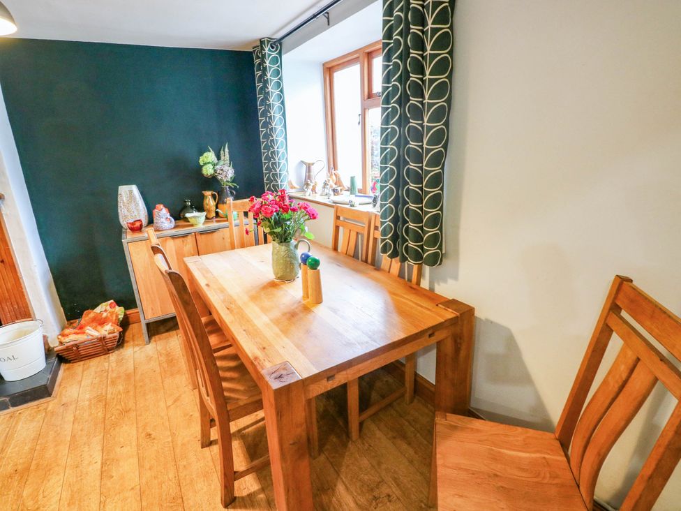 A dining room with a wooden table and chairs at Greig House Farm, Abergavenny