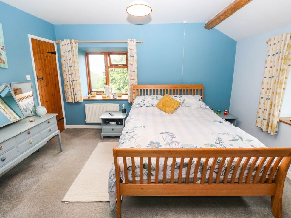 A bedroom with a bed and dresser at Greig House Farm in Abergavenny