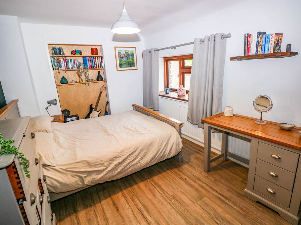 A bedroom with a bed and bookshelves at Greig House Farm Abergavenny