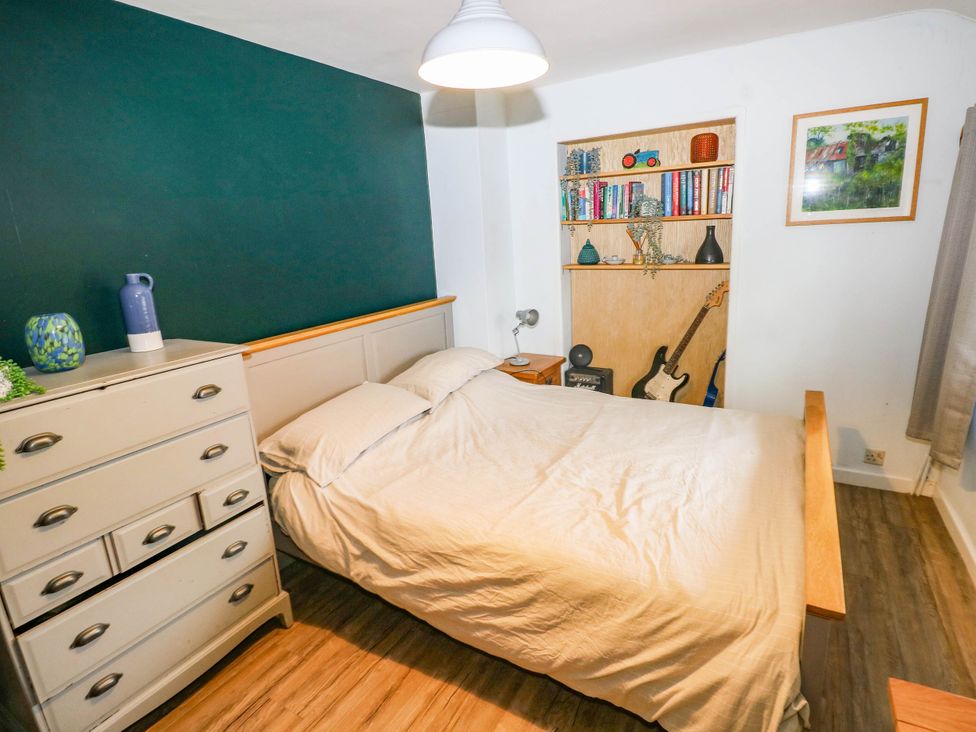 A bedroom with a bed and bookshelf at Greig House Farm Abergavenny