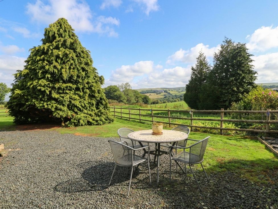 An outdoor seating area with a table and chairs at Greig House Farm Abergavenny