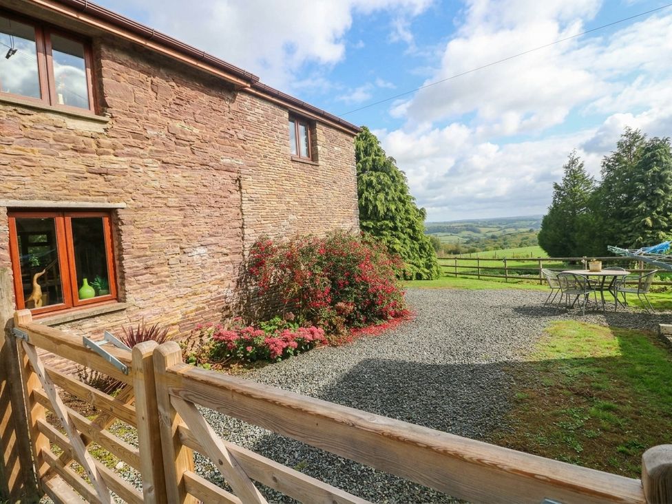 An outdoor area with flowers and a table at Greig House Farm Abergavenny