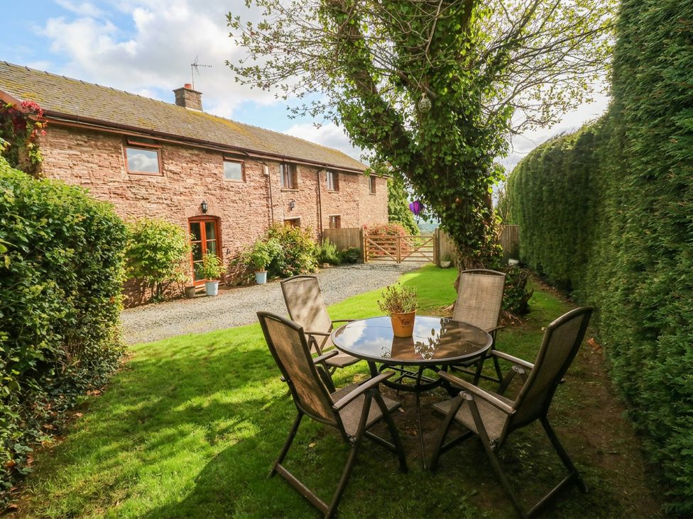 A garden area with a table and chairs at Greig House Cottage Abergavenny