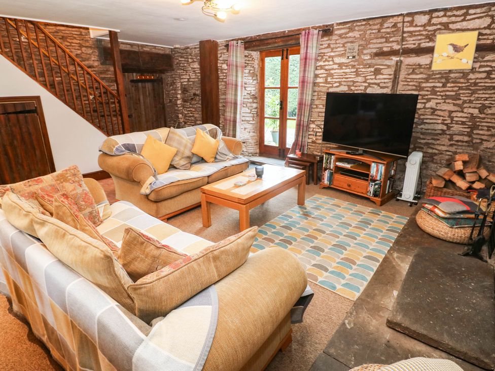 A living room with a television and coffee table at Greig House Cottage Abergavenny