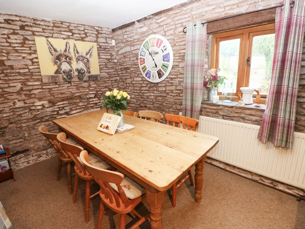 A dining room with a wooden table and chairs at Greig House Cottage Abergavenny