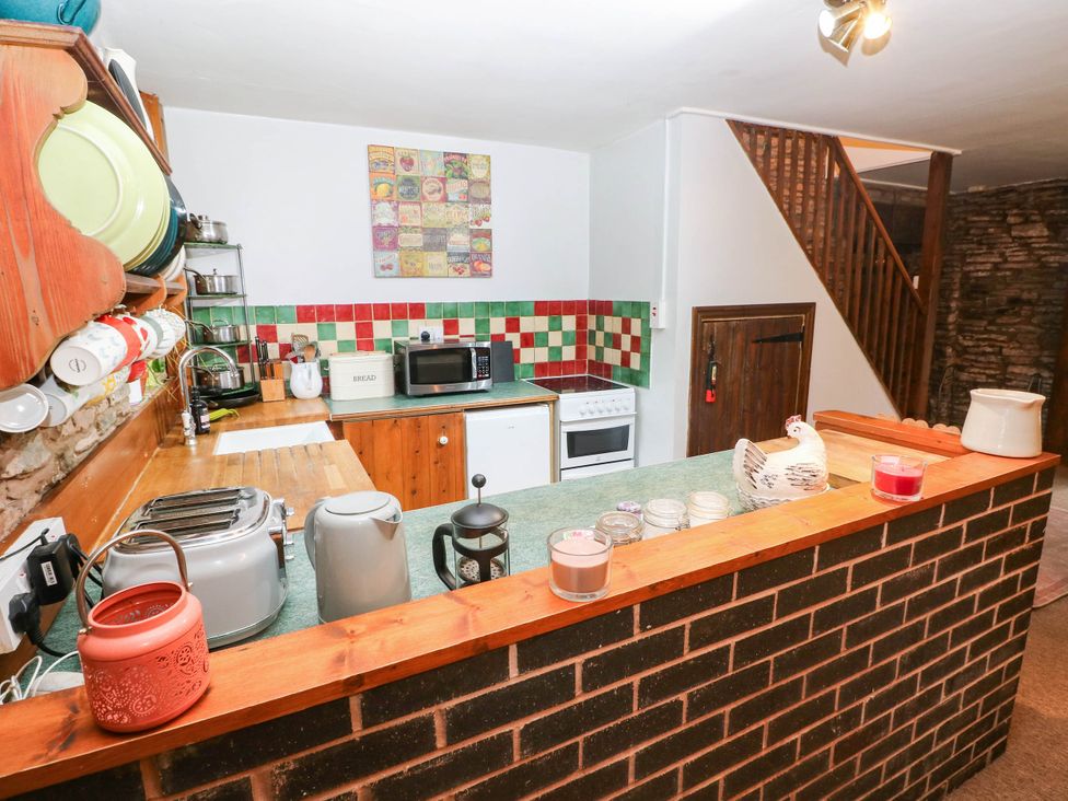 A kitchen with appliances and dishes at Greig House Cottage in Abergavenny