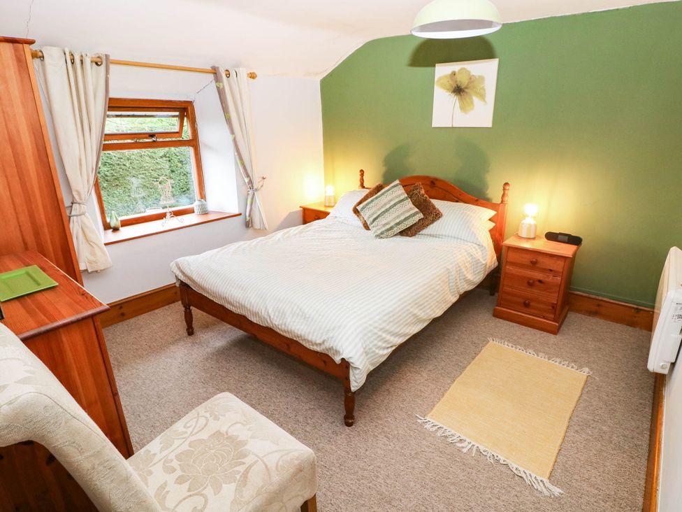 A bedroom with a bed and bedside table at Greig House Cottage Abergavenny
