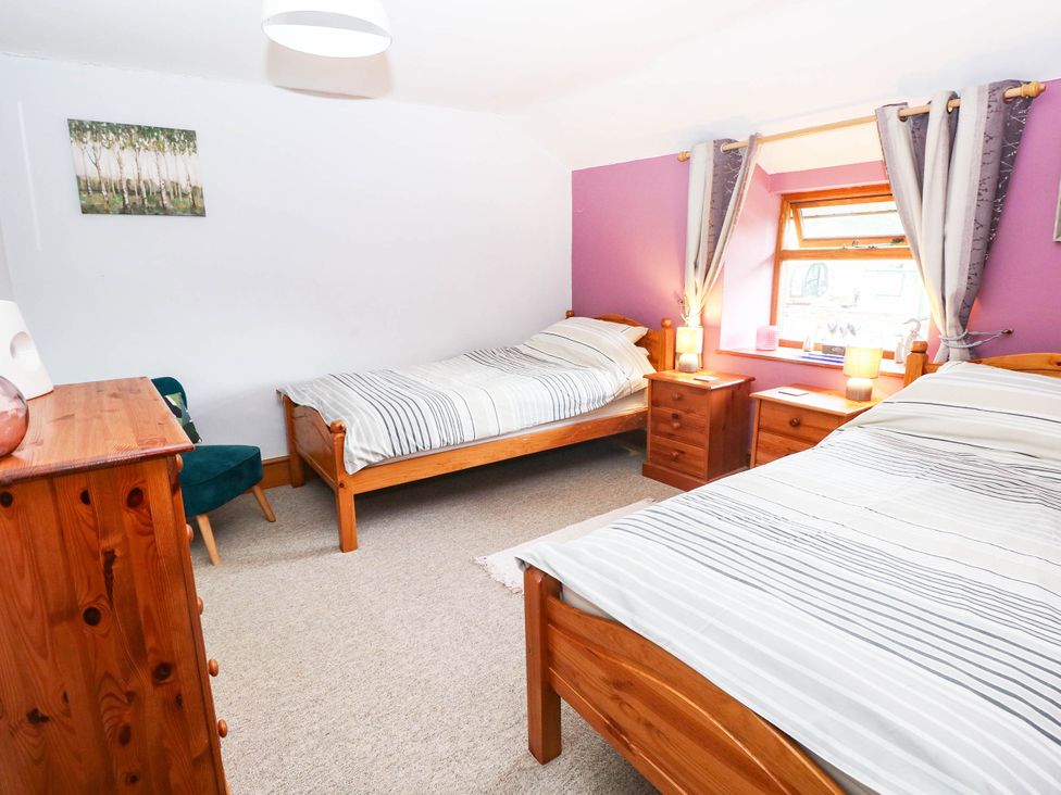 A bedroom with two beds and nightstands at Greig House Cottage Abergavenny