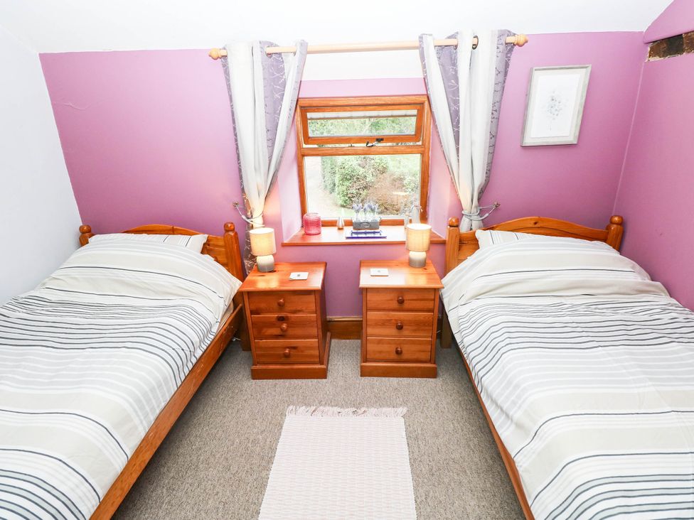 A bedroom with two beds and a window at Greig House Cottage Abergavenny