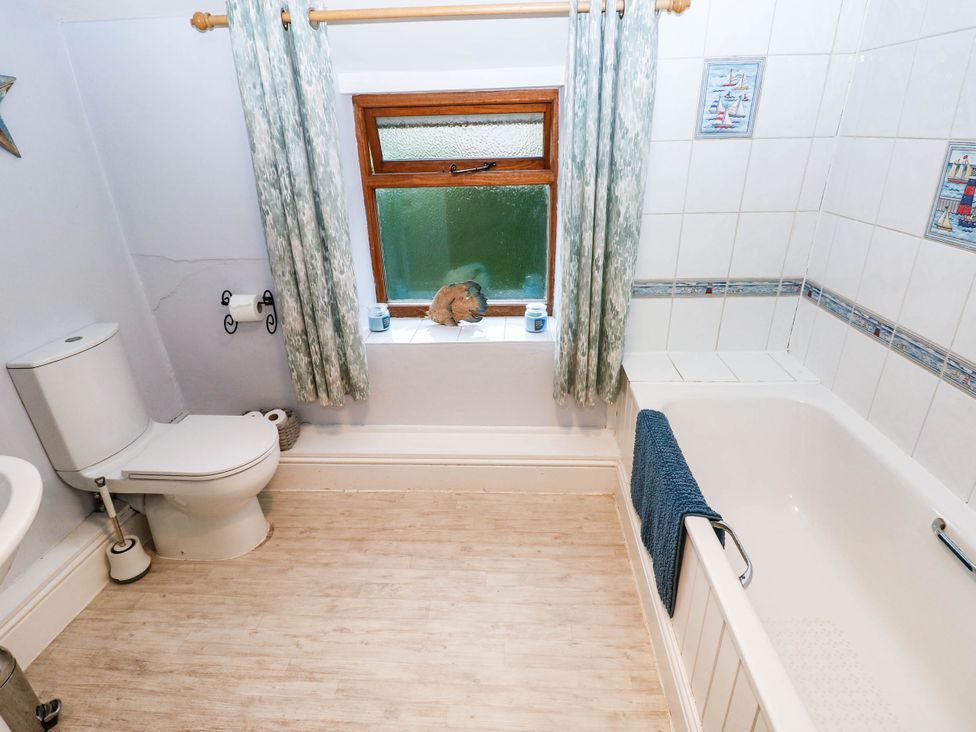 A bathroom with a toilet and bathtub at Greig House Cottage Abergavenny