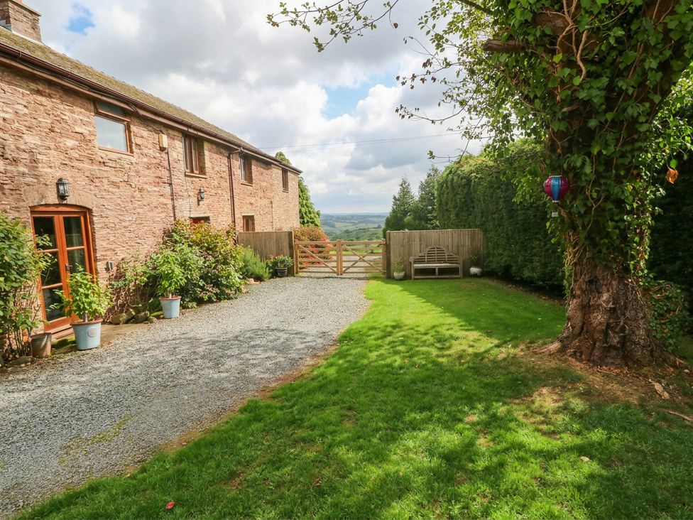 An outdoor area with a stone building and pathway at Greig House Cottage Abergavenny