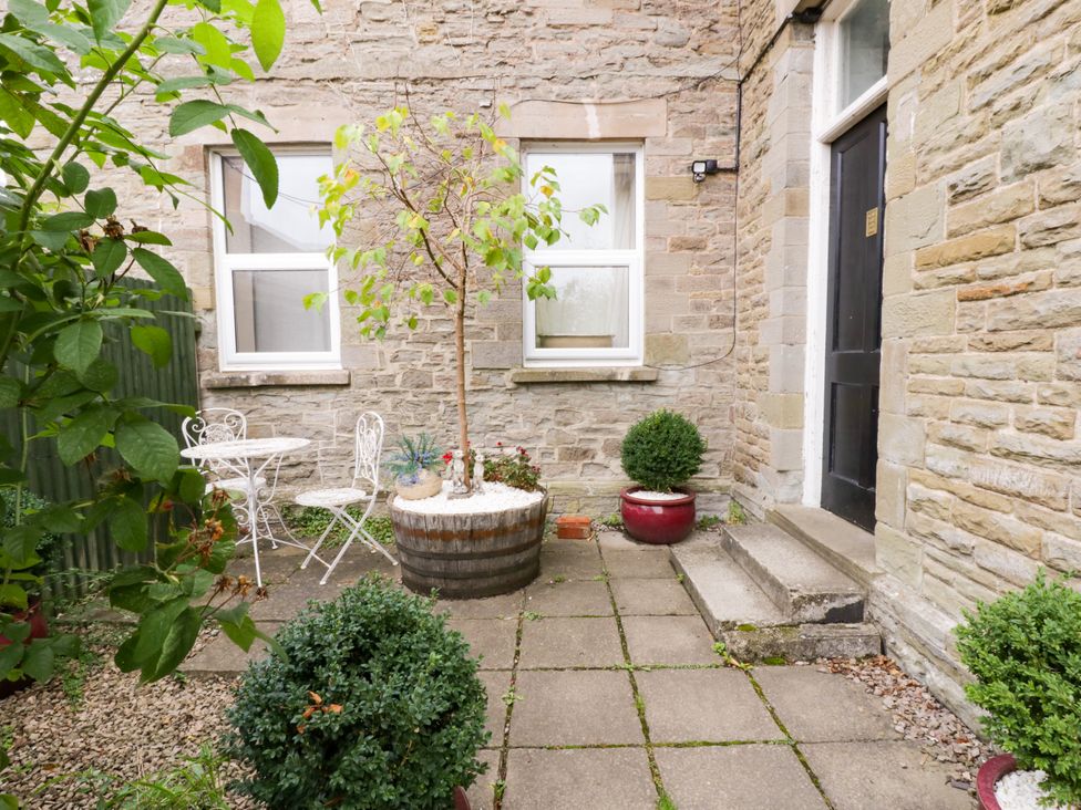 A garden with a table and chairs and a tree at Flat 5 Hereford