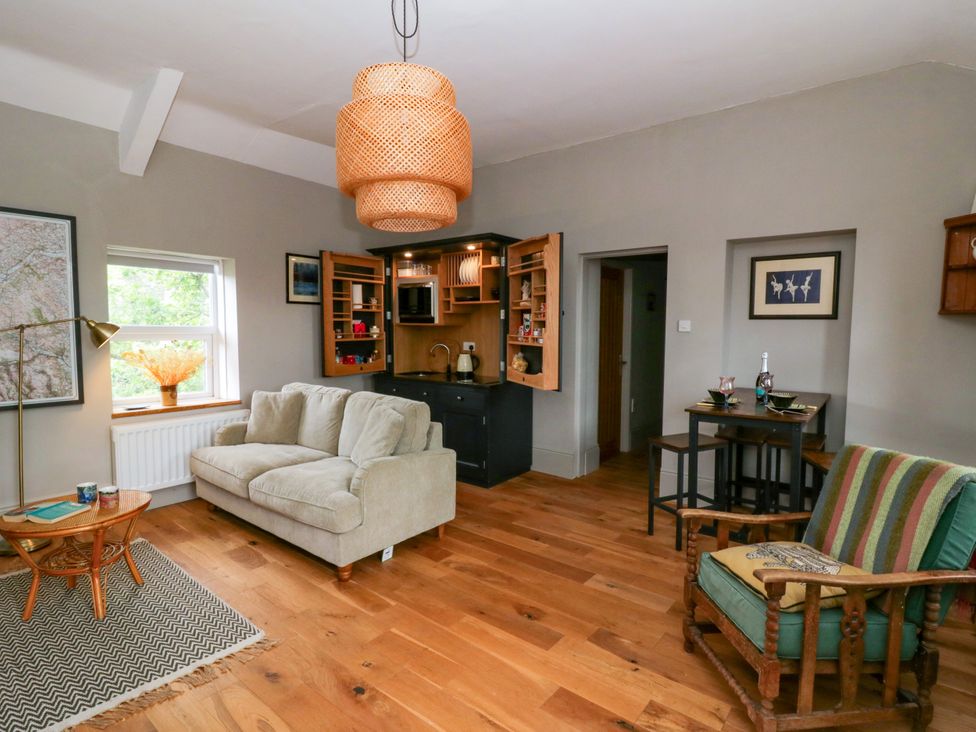 A living room with a sofa and bookshelf at Flat 5 Hereford