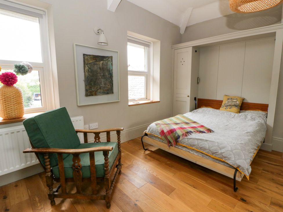 A bedroom with a bed and a rocking chair at Flat 5 Hereford