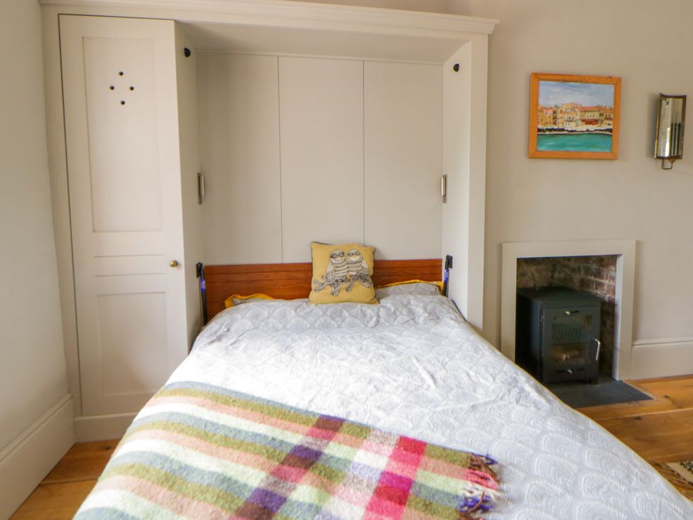 A bedroom with a bed and a painting at Flat 5 Hereford