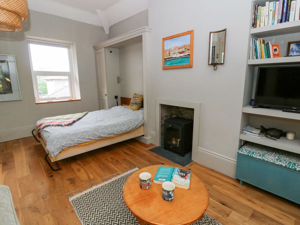 A bedroom with a folding bed and coffee table at Flat 5 in Hereford