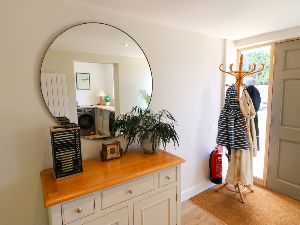 A hallway with a mirror and coat rack at 7 Forge Close