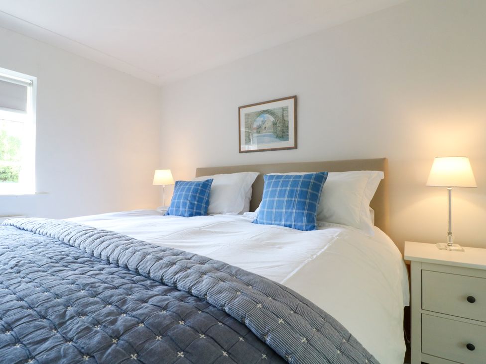 A bedroom with two beds and bedside lamps at 7 Forge Close