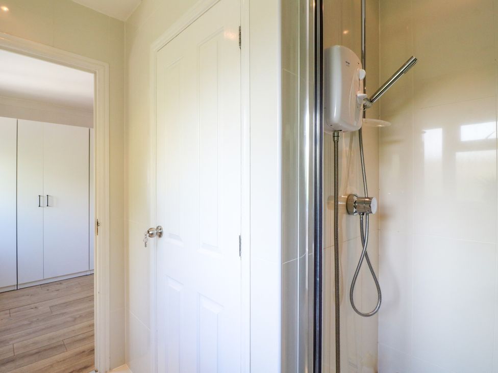 A shower with a shower head and door at 7 Forge Close
