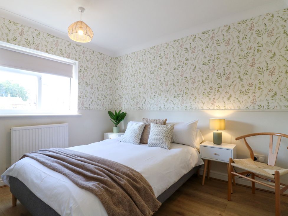 A bedroom with a bed and side table at 7 Forge Close