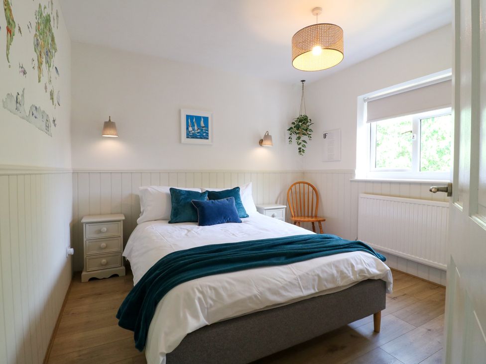 A bedroom with a bed and a chair at 7 Forge Close