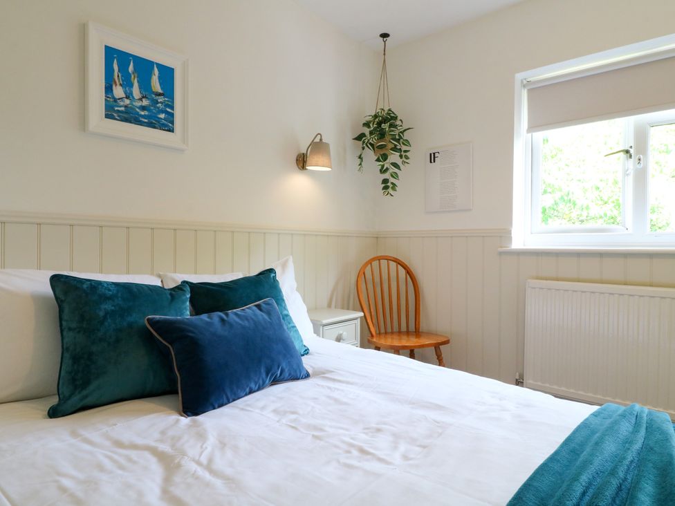 A bedroom with a bed and a chair at 7 Forge Close