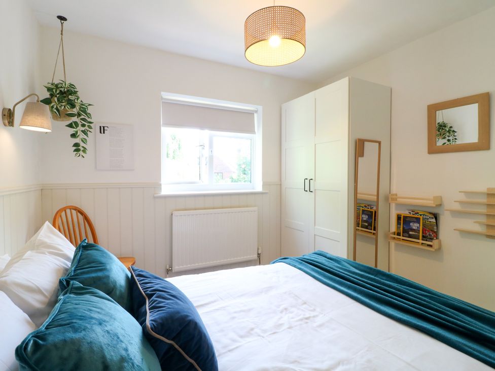A bedroom with a bed, wardrobe, and window at 7 Forge Close 