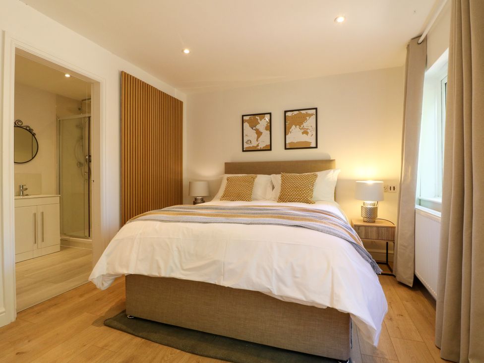 A bedroom with a bed and attached bathroom at 7 Forge Close